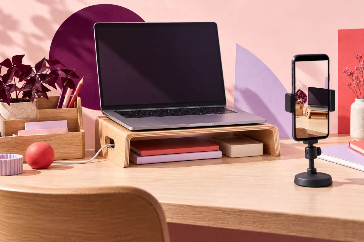 A phone filming a laptop stand, desk organiser and cable storage.